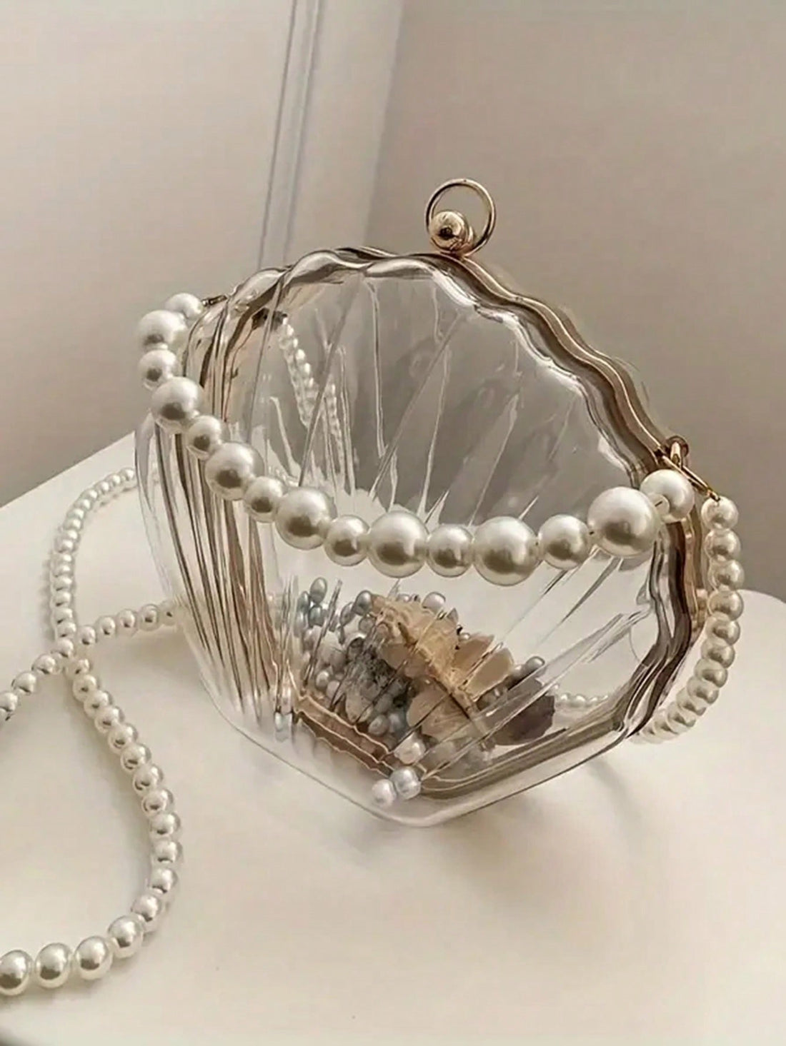Elevate your style with our 2024 Women's Shell Shaped Clutch. This chic acrylic handbag is perfect for the beach, sports, and picnics. Its unique design and durable material make it a versatile accessory for any occasion. Add this must-have piece to your collection today.