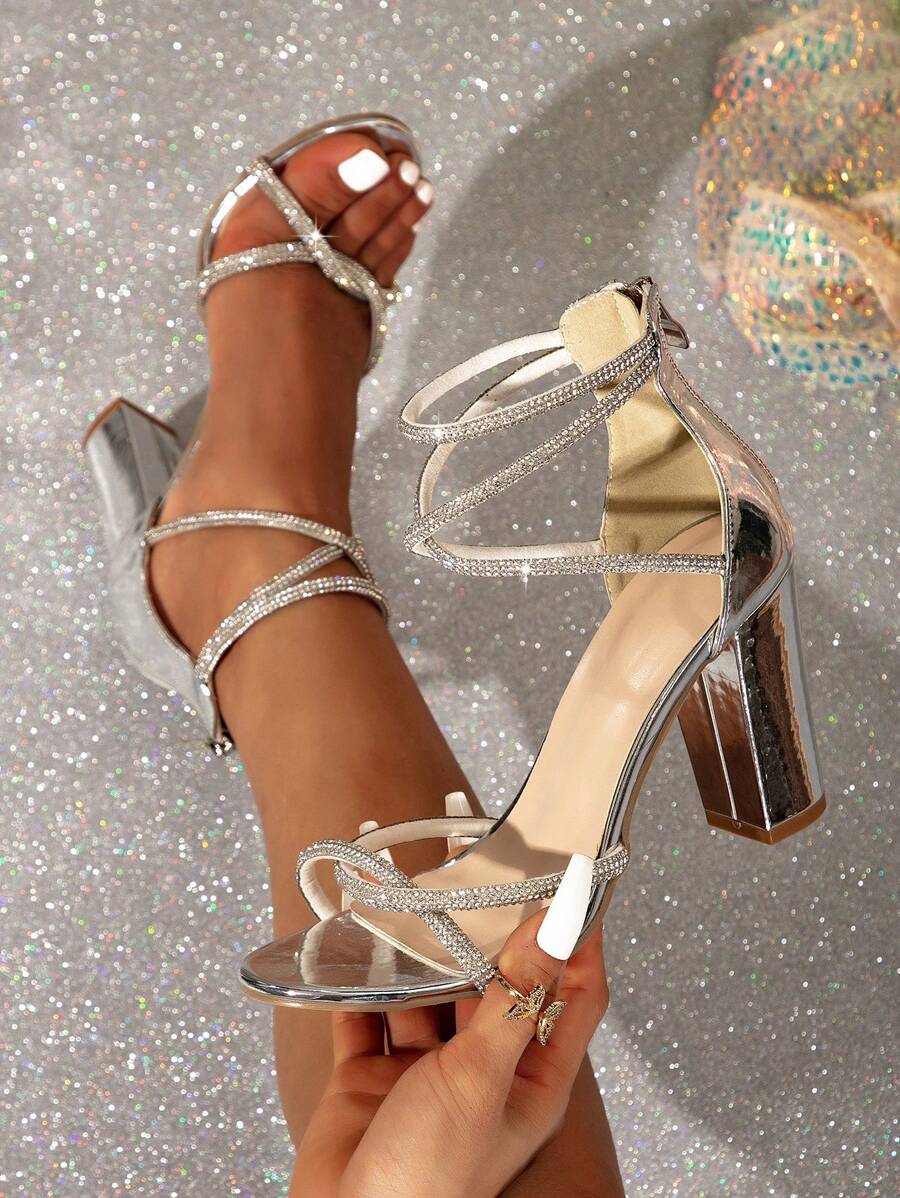 Handheld silver open toe heel sandals with crystal straps and metallic finish