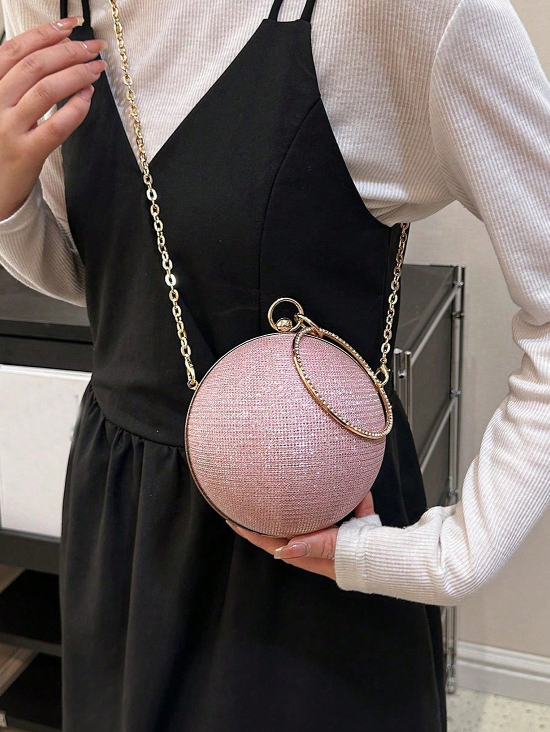 This miniature handbag is designed to make a statement with its shimmering sphere shape and glittery texture. Perfect for adding a touch of glam to any outfit, it's a must-have accessory for any fashionista. Crafted with precision and attention to detail, this handbag is sure to turn heads and catch the eye of any fashion lover.