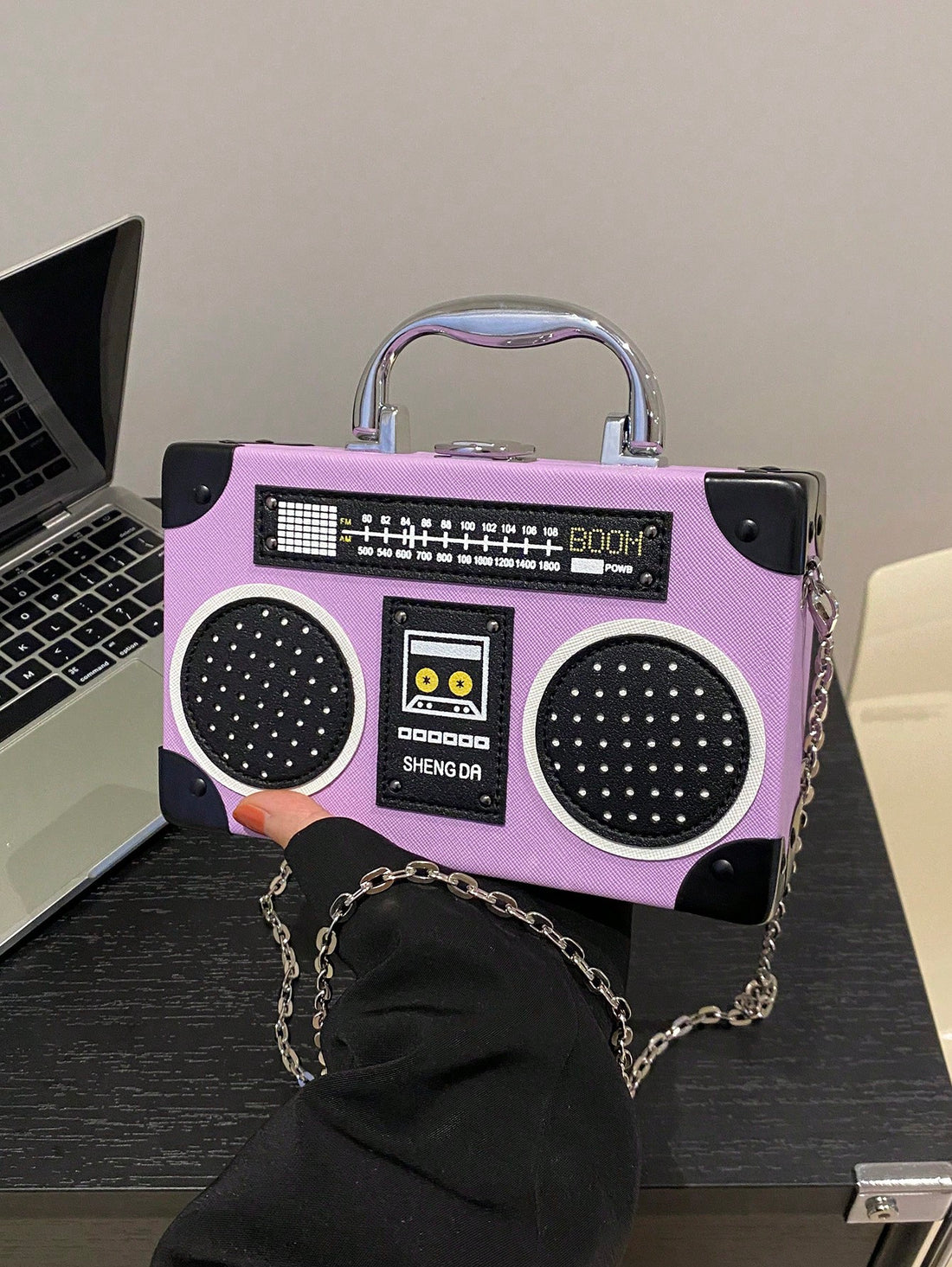 Introducing the Radiant Melody: Purple Radio Handbag, a trendy music-inspired crossbody bag. With its stylish design and convenient crossbody strap, this bag is perfect for carrying all your essentials while adding a touch of music to your outfit. Made from high-quality materials, it is both durable and fashionable. Elevate your fashion game with this must-have accessory.