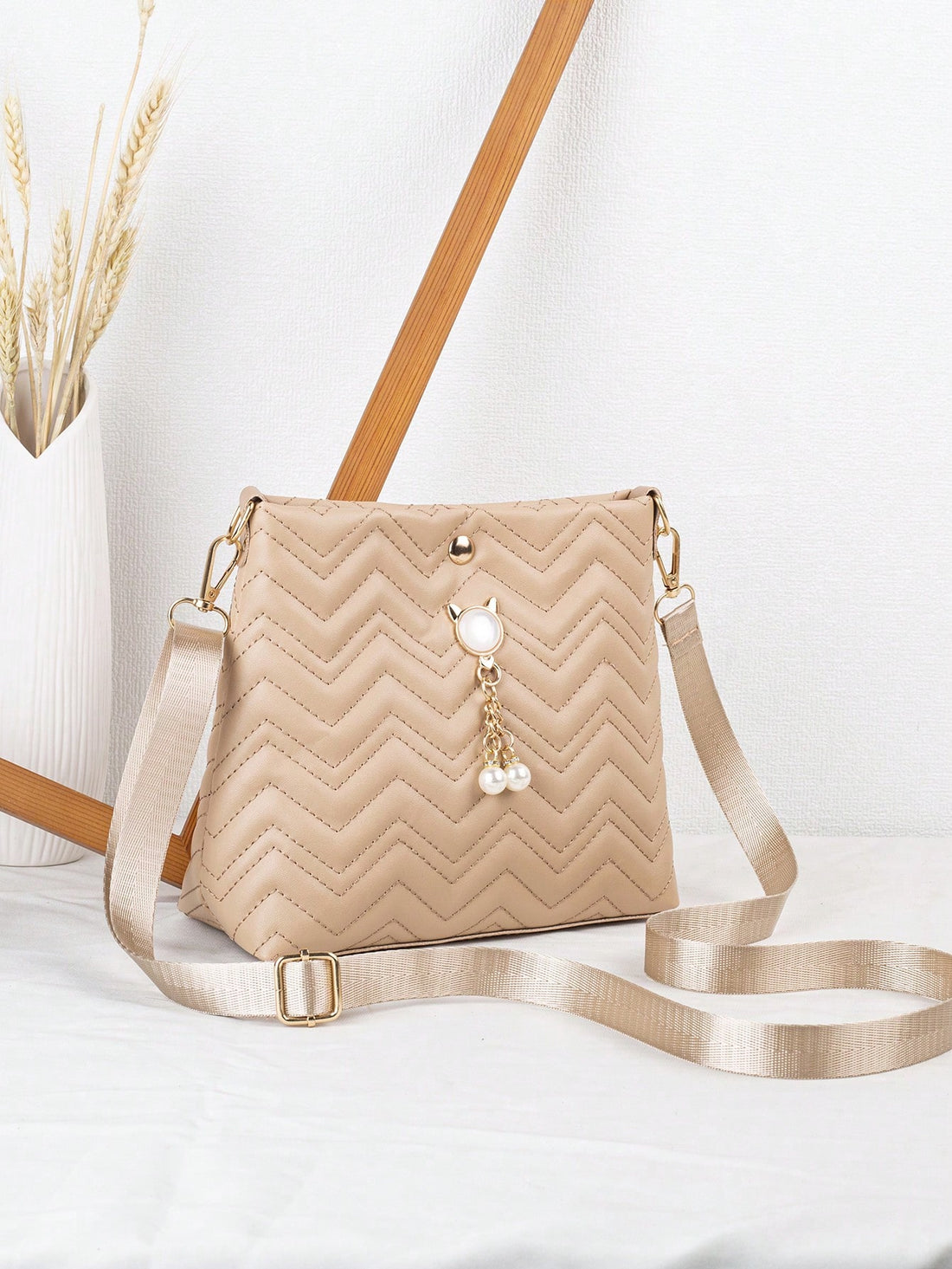 Introducing the Chic Faux Pearl Crossbody Bag - the perfect combination of style and functionality. Made with high-quality materials, our bag features an adjustable strap for comfortable wear and stylish car stitching for added flair. Perfect for any occasion, this bag is a must-have for any fashion-forward individual.