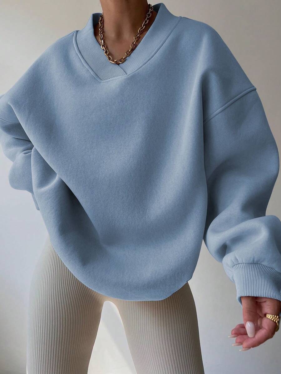 Front view of baby blue oversized V-neck sweatshirt with loose long sleeves