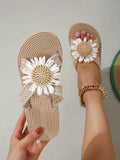 Handheld top view of braided cross-strap sandals with flower appliques and coiled footbed