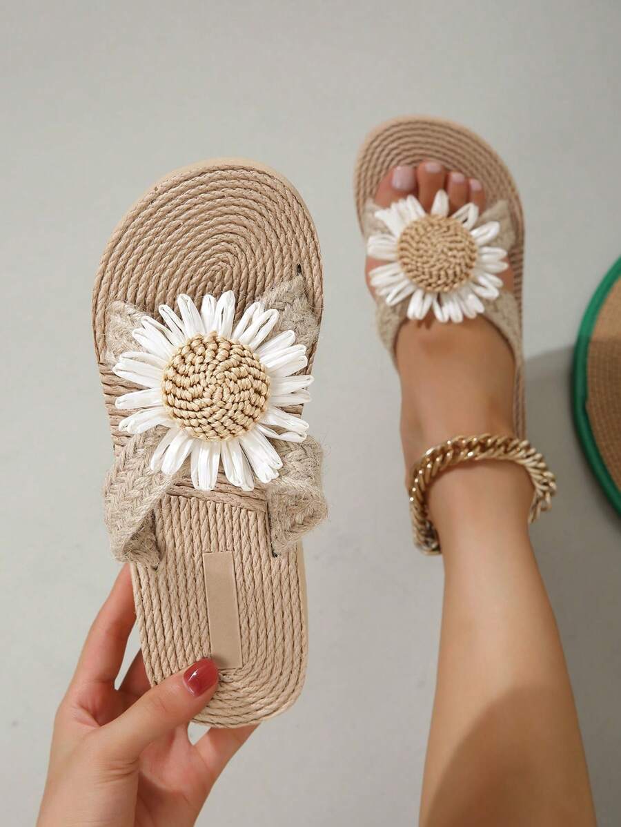 Handheld top view of braided cross-strap sandals with flower appliques and coiled footbed