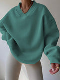 Front view of mint green oversized V-neck sweatshirt with loose long sleeves