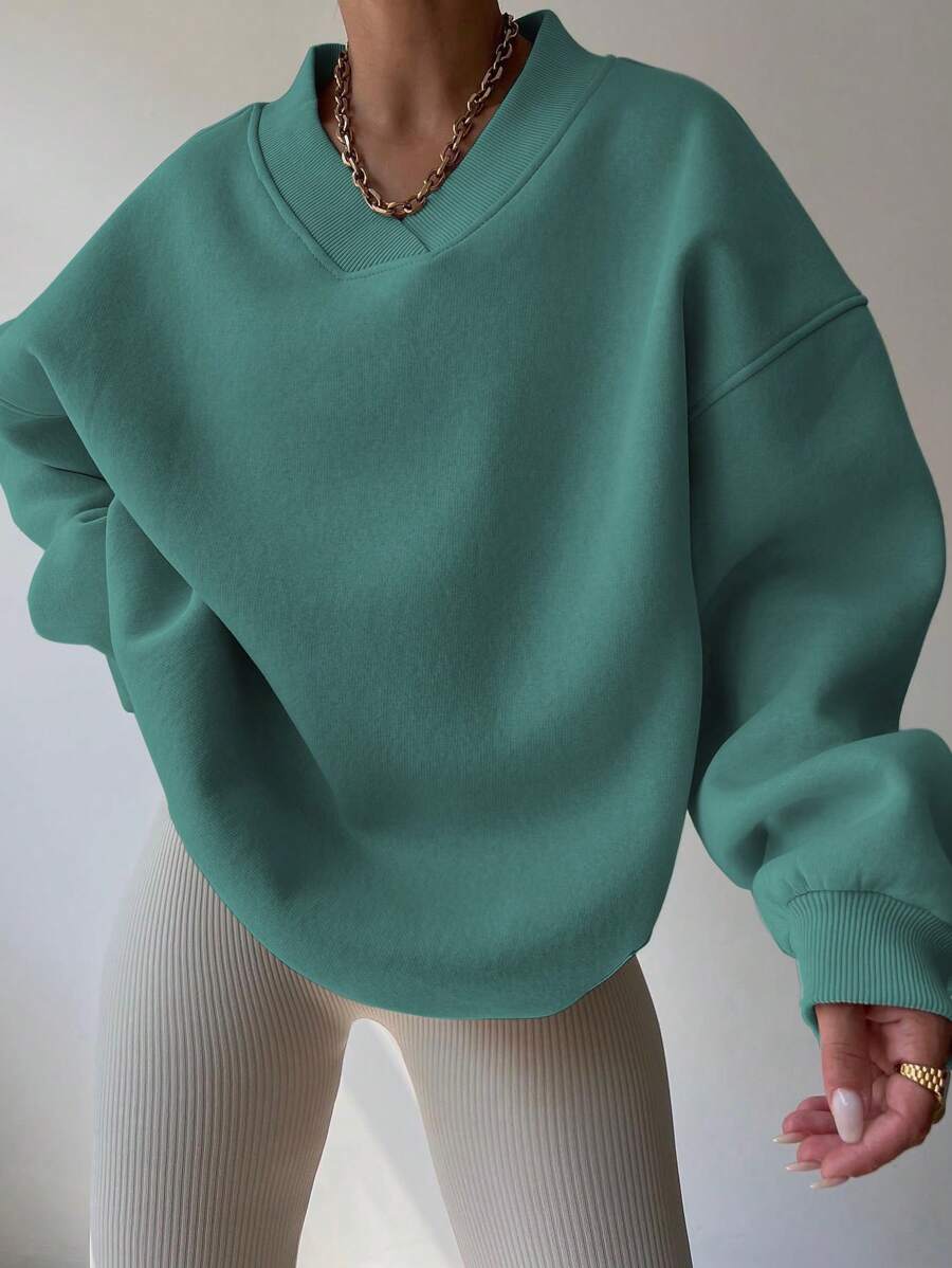 Front view of mint green oversized V-neck sweatshirt with loose long sleeves