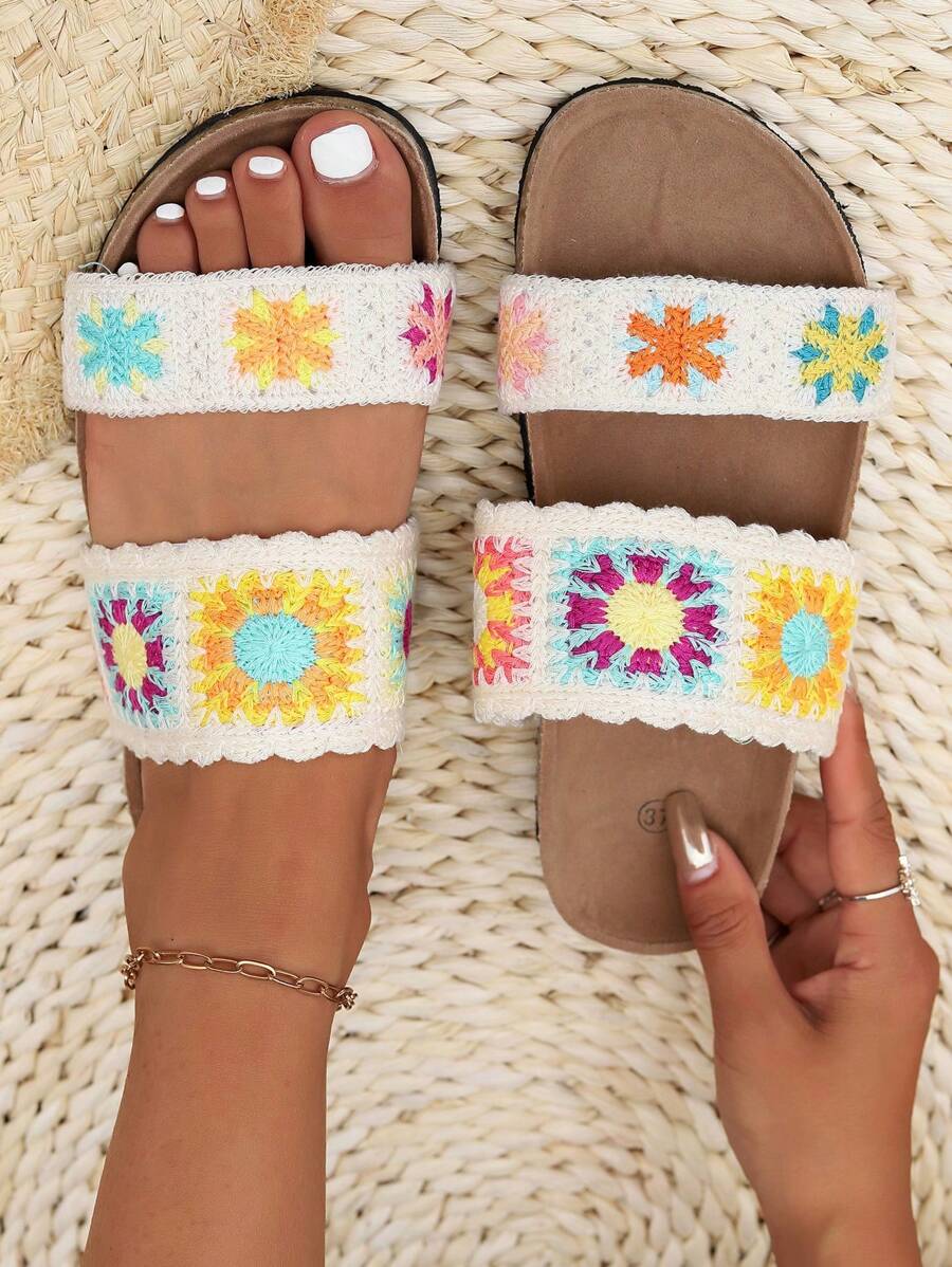 Cream crochet floral slide sandals with colorful sunflower straps and tan footbed.