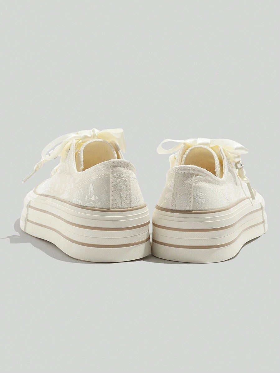 Cream low-top platform sneakers with satin ribbon laces rubber toe cap jacquard floral upper and beige sole stripes