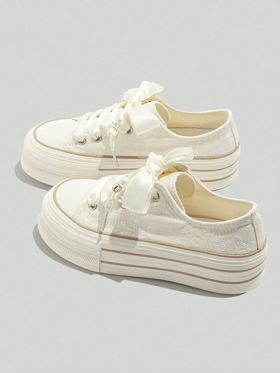 Cream low-top platform sneakers with satin ribbon laces rubber toe cap jacquard floral upper and beige sole stripes