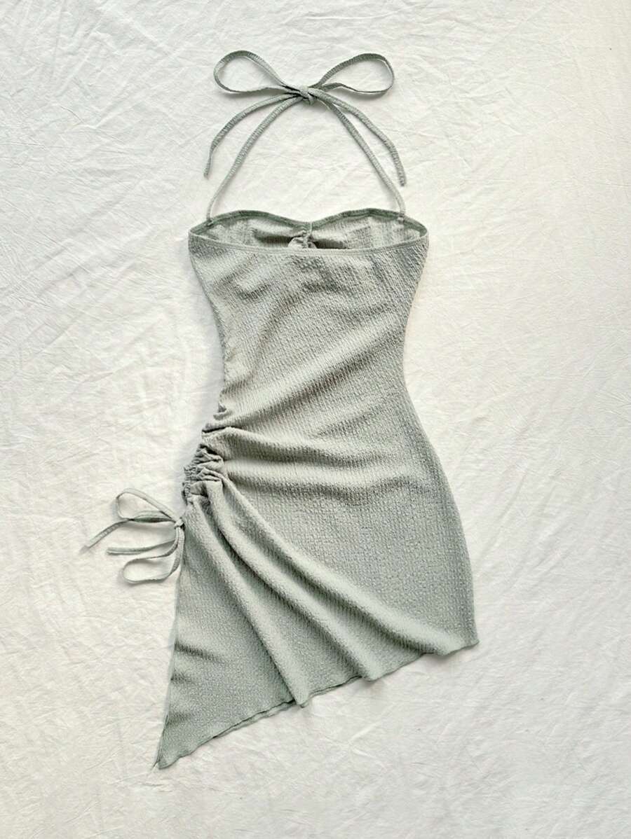 Elevate your summer wardrobe with this chic pastel halter neck dress featuring an eye-catching asymmetrical hem. The backless design and lettuce trim detailing create a trendy, modern silhouette perfect for casual outings and warm-weather occasions. Crafted from a soft knitted fabric blend of 95% polyester and 5% elastane, this sleeveless mini dress offers a comfortable slim fit with just the right amount of stretch. The natural waistline flatters your figure while the unlined construction keeps you cool. E