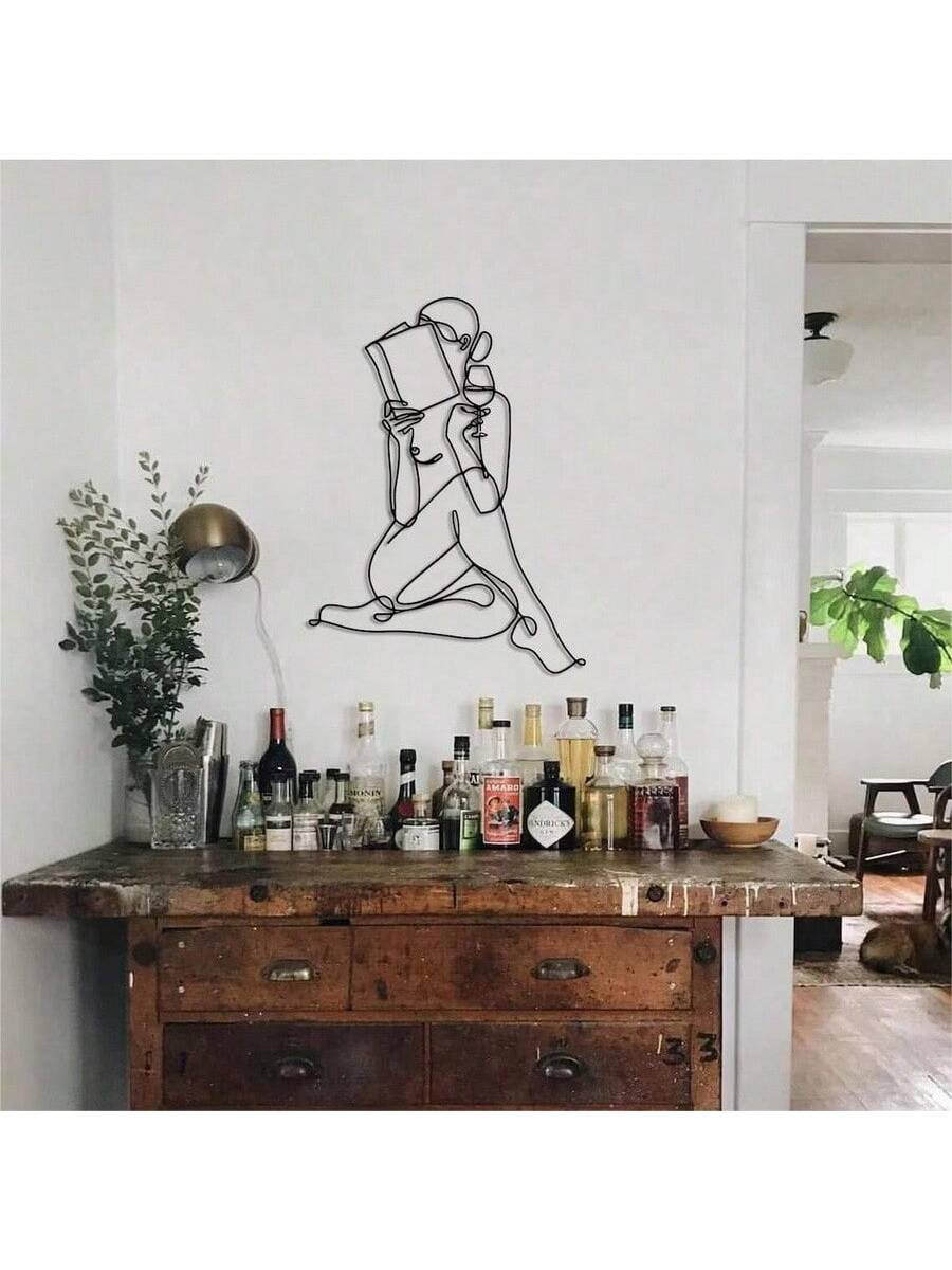 Enhance your home decor with this elegant Chic One Line Metal Wall Art. This unique piece features a stylish woman reading while enjoying a glass of wine, making it the perfect gift for book and wine lovers. With its sleek design, it is sure to add a touch of sophistication to any room.