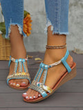 Close front view of turquoise crystal open-toe sandals with floral straps