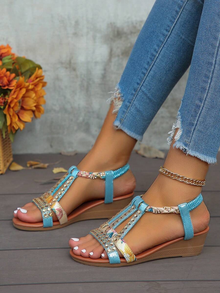 Side profile of blue embellished slingback wedge sandals showing the platform heel