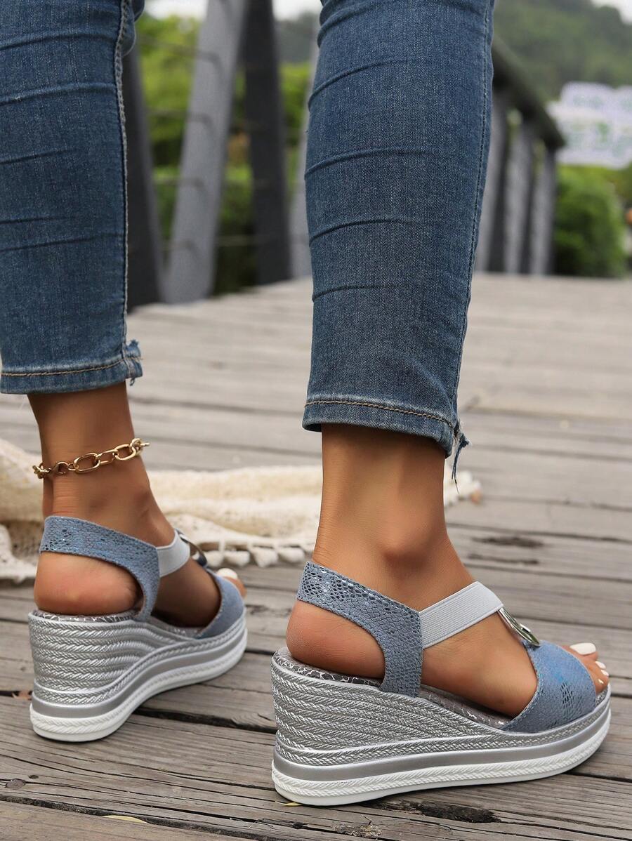 Rear three-quarter view of dusty blue platform sandals showing elastic slingback straps