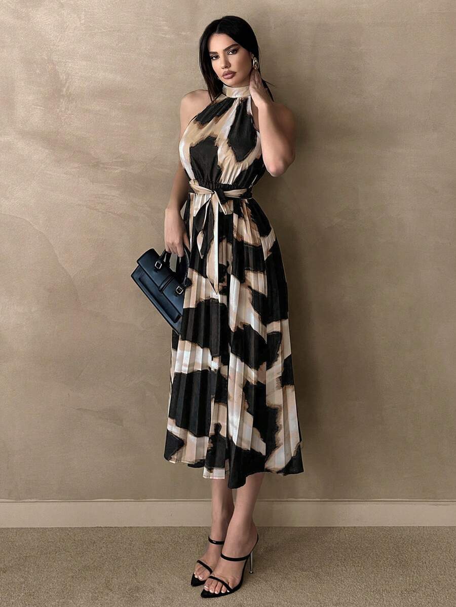 Front view of abstract print pleated halter midi dress with tie belt