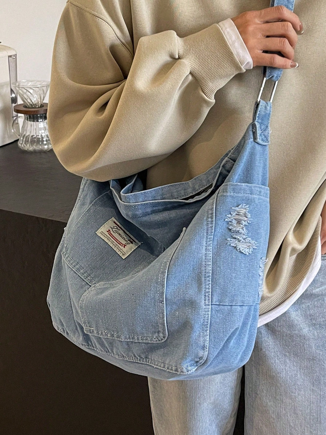 Elevate your everyday carry with this vintage-inspired crossbody bag, crafted from distressed blue material that develops character with use. The spacious interior accommodates daily essentials while multiple pockets keep your belongings organized and accessible. Designed for versatility, this tote transitions seamlessly from casual outings to weekend adventures. The adjustable crossbody strap offers hands-free convenience and comfortable wear throughout the day. Perfect for those who appreciate timeless st