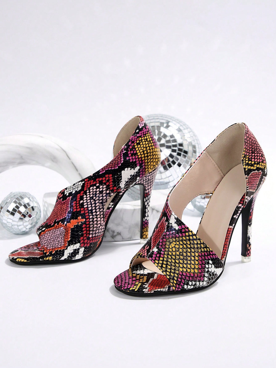 Introducing Snake Charmers: Women's Asymmetric High Heel Sandals for Evening Parties. With an eye-catching and unique asymmetric design, these sandals are perfect for adding a touch of intrigue to any evening outfit. The high heel provides a flattering lift, while the snakeskin print adds a subtle edge. Elevate your party look with these statement heels.