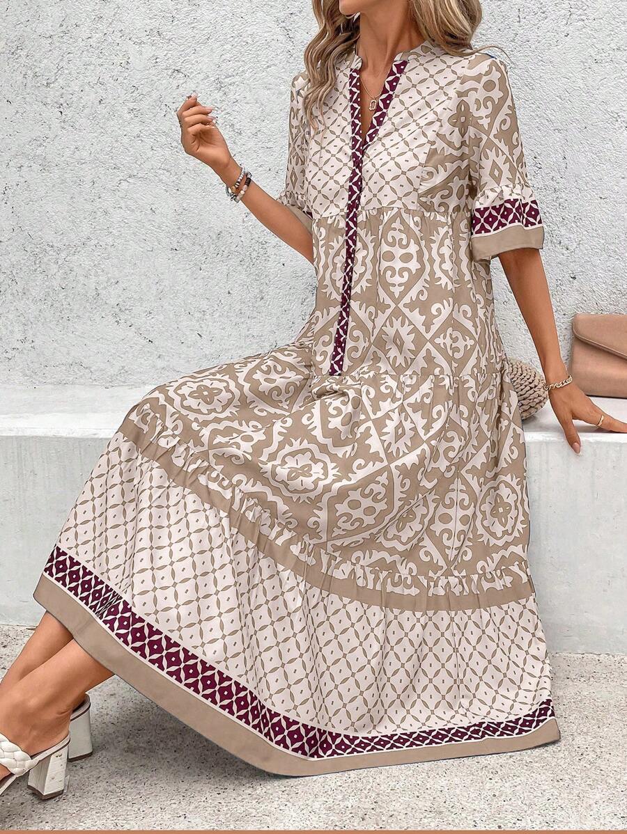 Seated view of beige retro print dress showing wide ruffle hem