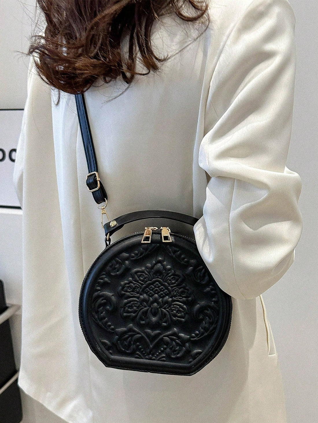 This vintage flower embossed round handbag is a chic essential for any commuter. The exquisite design adds a touch of elegance to your daily travels. With its spacious interior, it's perfect for carrying your everyday essentials. Travel in style and convenience with this must-have accessory.