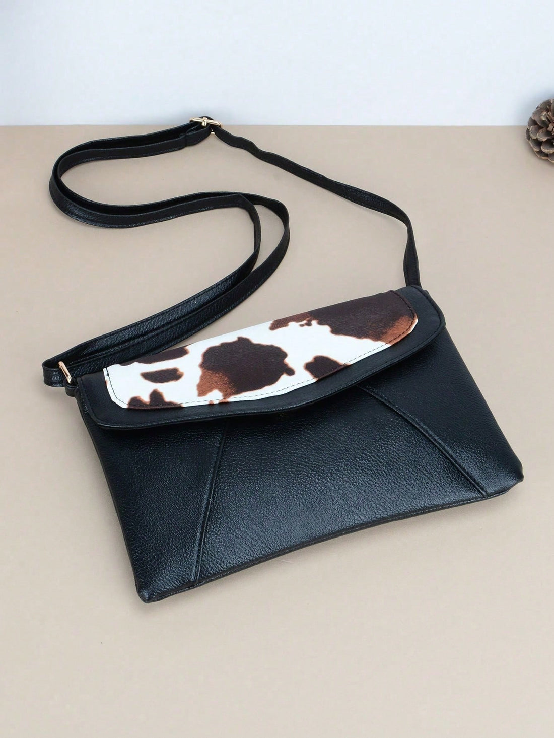 Add a touch of whimsy to your ensemble with our Moo-ve in Style Cow Pattern Crossbody Bag. Perfect for festivals and daily use, this fun envelope bag combines functionality with fashion. Its crossbody design allows for hands-free convenience, while its cow pattern adds a playful touch. Moo-ve in style today!