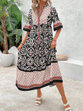 Front pose of black retro graphic midi dress with notched neckline