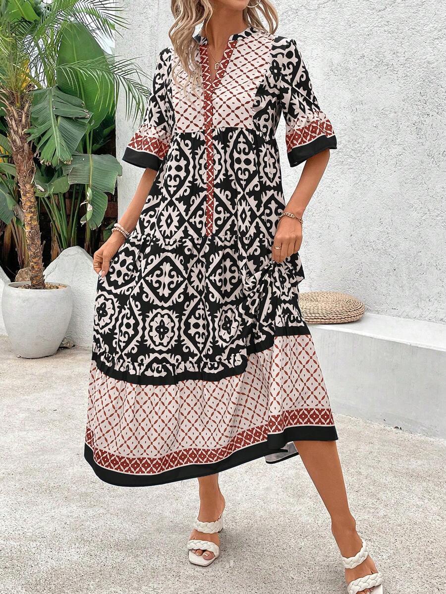 Front pose of black retro graphic midi dress with notched neckline