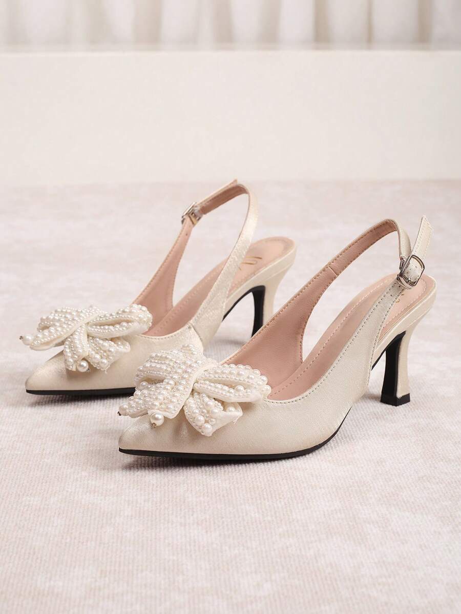Ivory pearl bow slingback pump worn on foot with pointed toe