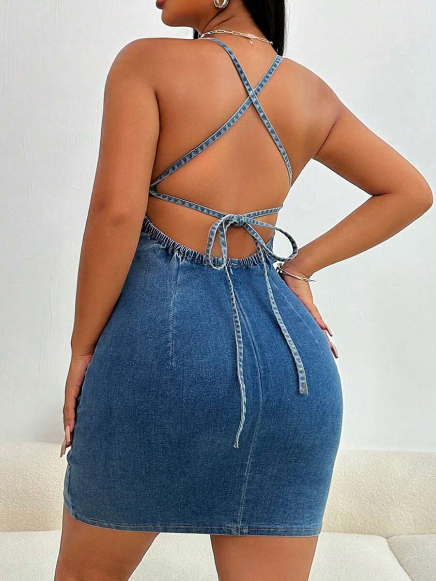 Model wearing blue denim bodycon mini dress with plunging V-neck, spaghetti straps, cross-back tie detail shown in inset