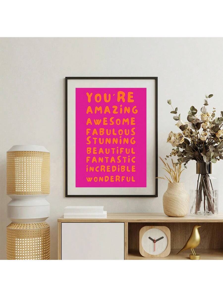 Framed pink motivational quote poster with orange typography in a room setting