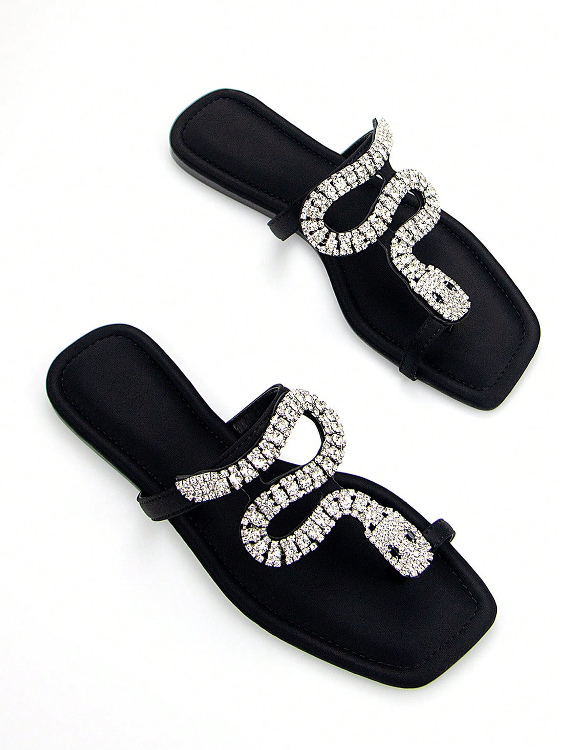 Discover the ultimate combination of elegance and comfort with our Elegantly Chic 3D Snake Crystal Chain Black Lycra Slip-On Flat Mule Sandals. Featuring a stunning 3D snake crystal chain design and a slip-on style for easy wear, these sandals are perfect for any occasion. Walk in style and comfort with our chic and trendy flats.