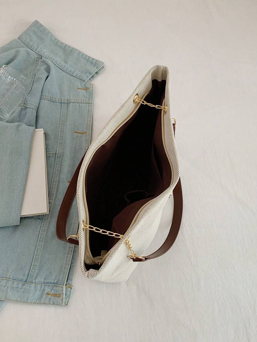 Open beige tote bag showing dark brown lined interior top zipper edge gold chain detail brown straps and inner pocket