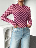 Front styled view of pink checkerboard fitted knit top with lettuce-trim edges