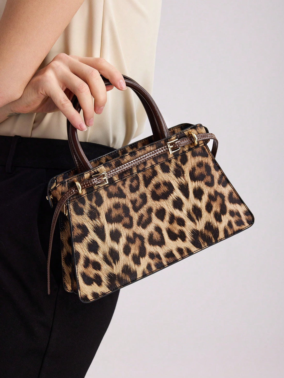 Add a sophisticated touch to your wardrobe with this chic leopard print buckle top handle bag. With its sleek design and trendy pattern, this bag is the perfect accessory to elevate your style. Made from high-quality materials, it's durable and fashionable.