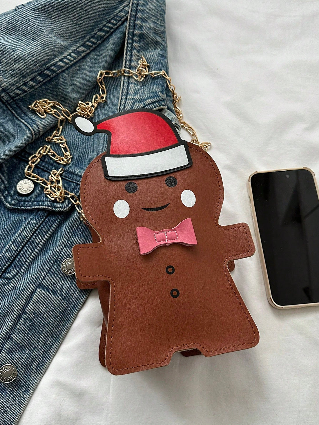 This festive and charming shoulder bag, inspired by a gingerbread man, is the perfect gift for the holiday season. The asymmetric design adds a unique touch while providing ample space for all your essentials. Spread holiday cheer with this fun and functional accessory.