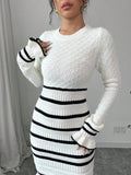 Close-up of white diamond-knit sweater dress with ribbed striped waist, long sleeves, and flared cuffs