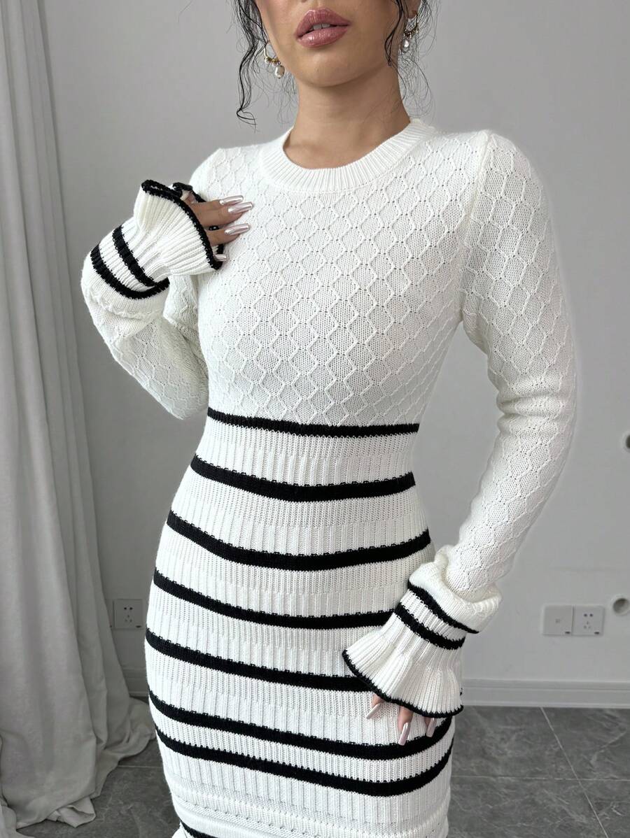 Close-up of white diamond-knit sweater dress with ribbed striped waist, long sleeves, and flared cuffs