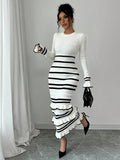 White striped knit midi dress with round neck, flared cuffs, and tiered ruffles styled with a black bag