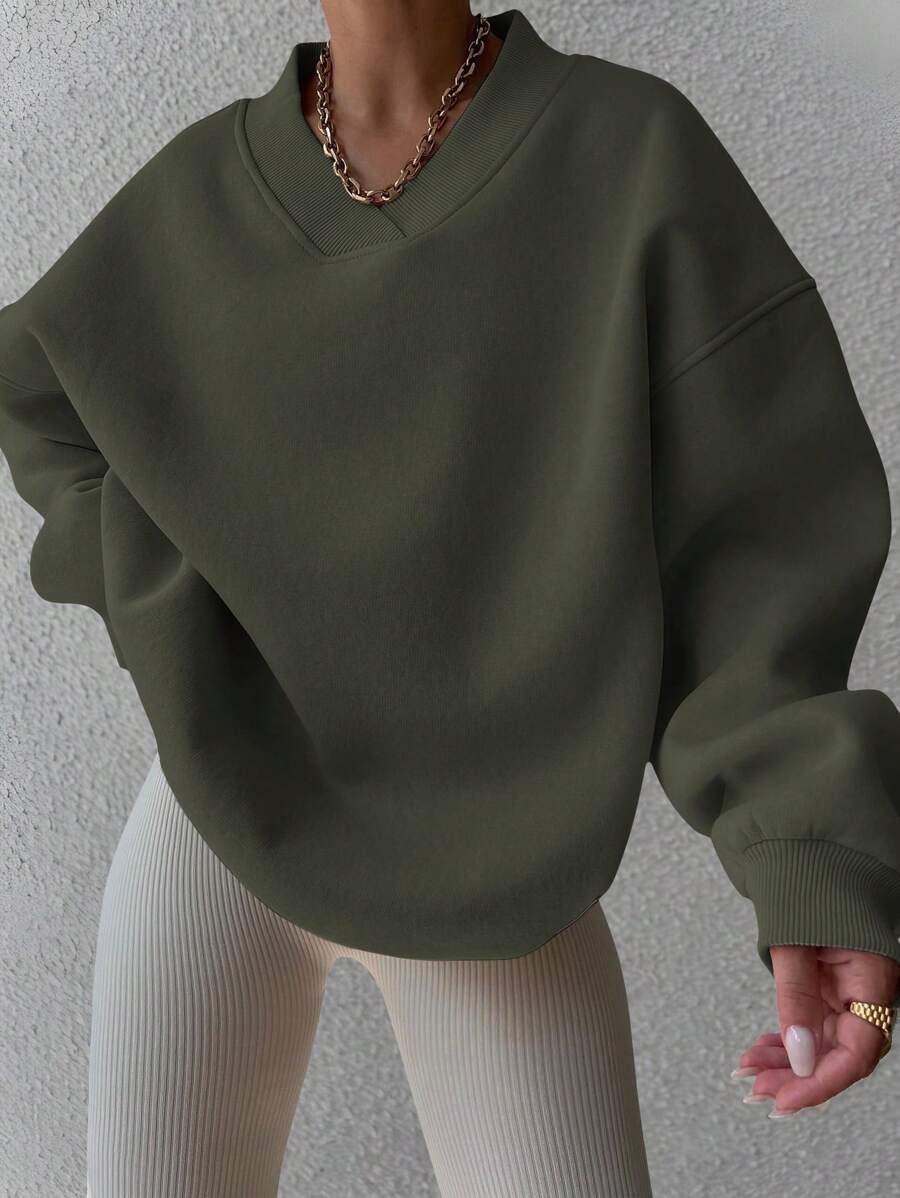 Front view of dark green oversized V-neck sweatshirt with balloon sleeves