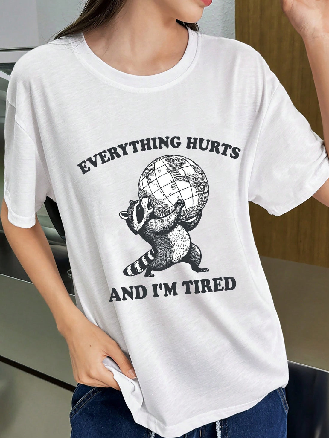 This Charming Raccoon Graphic Tee is not your average t-shirt. Featuring a fun slogan and a cute raccoon graphic, this round neck tee is sure to turn heads. Made for women, it combines style and comfort in one charming package. Perfect for any casual occasion, this tee is a must-have for your wardrobe.