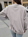 Back worn view of plain grey drop-shoulder sweatshirt styled with light blue jeans