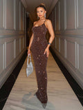 Front three-quarter view of brown rhinestone maxi gown styled with metallic evening accessories
