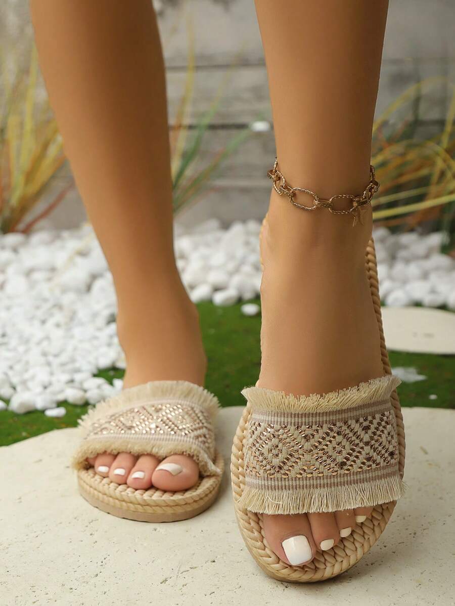 High-angle on-foot view of beige fringed geometric platform slide sandals outdoors