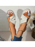 Angled view of white open toe rhinestone slides with clear jewel detail