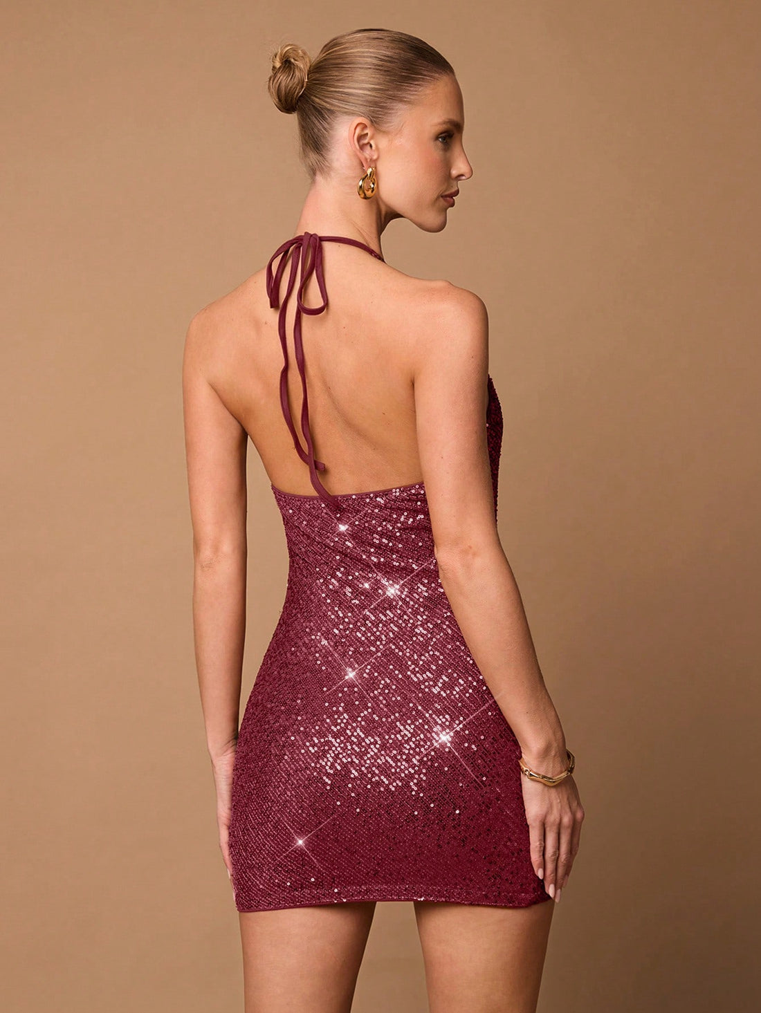 Get ready to shine in our Shimmering Elegance dress! This dazzling mini features a deep V neckline, halter design, and backless cut. Covered in shimmering sequins, you'll stand out and make unforgettable memories. Perfect for special nights out.