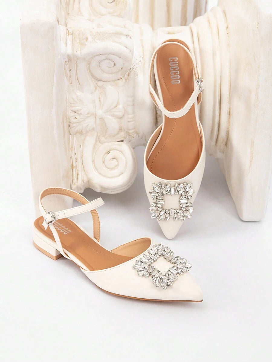 Front view of white pointed toe slingback flats with low square heels and side buckles