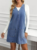 Full front view of medium blue A-line denim mini dress with two oversized patch pockets