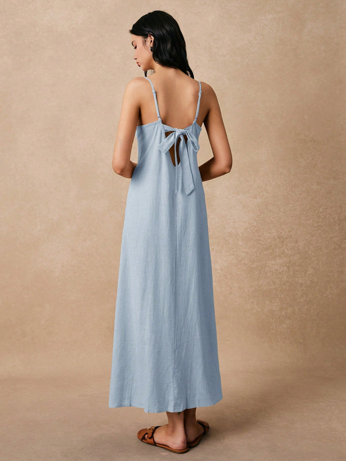 Slip into vacation mode with this flirty backless linen dress! The delicate spaghetti straps and breezy fabric keep you cool while turning heads at the beach bar. Perfect for tossing over your swimsuit or dressing up with sandals for sunset strolls. This carefree piece practically packs itself – wrinkles just add to the laid-back charm!