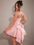 Back view of baby pink fit and flare mini dress with oversized bow and open back