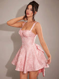 Angled front view of pink bow-back party mini dress with textured floral jacquard