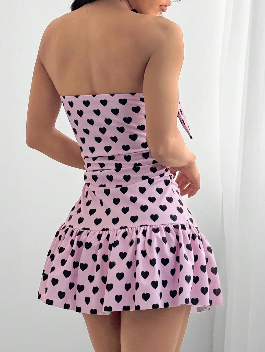 Effortlessly exude charm in this mini cami dress with a heart-shaped print and ruched detailing. Perfect for a fun and flirty style that's easy to achieve. Indulge in your playful side with this charming dress.